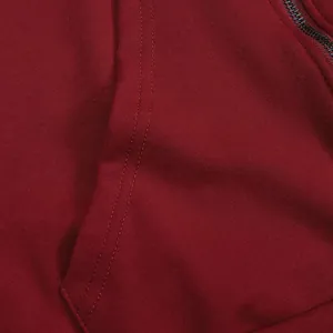 Detail macro view of reinforced pocket stitching on burgundy hooded sweatshirt dress