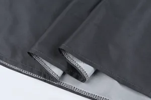 Detailed macro view showing the high-quality overlock stitching on the hem of a grey dress