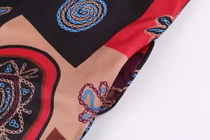 Gros plan sur l'imprimé géométrique rétro et la poche d'une robe longue colorée.