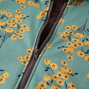 Macro view of women's floral coat showing zipper detail and thick brown fleece lining.