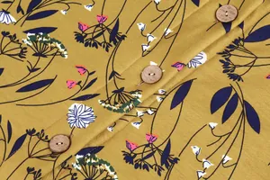 Macro detail of mustard floral fabric featuring three round natural wooden buttons.