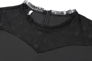 Macro view of black dress featuring polka dot mesh stitching and lace neckline trim