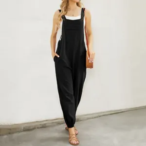 Detail of black cotton linen overalls with adjustable button straps and front pocket