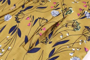 Close-up detail of mustard yellow floral jacket showing pocket and fabric texture