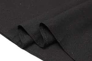 Close-up detail of black fabric with subtle sequin sparkles and clean hemline stitching