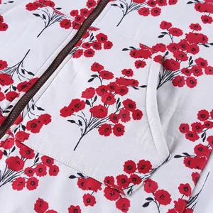 Detailed macro view of the zipper and pocket on a women's red floral print padded coat.