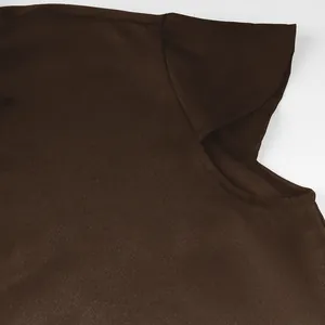 Close-up of dark brown medieval tunic fabric showing twill texture and shoulder seam