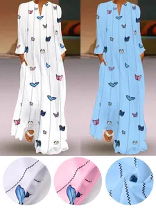 Détail en gros plan du motif de papillon coloré et de la texture du tissu d'une robe maxi