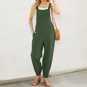 Close-up of casual dark green cotton linen overalls with front pocket and button details