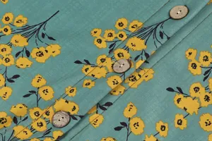 Detail of teal floral print jacket showing round wooden buttons and fabric texture