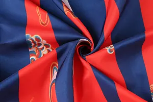 Detail eines seidigen Retro-Stoffs mit roten und blauen Streifen und Wolkenmuster.