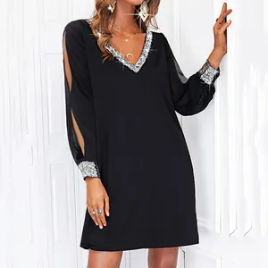 Dettaglio vestito nero corto scollo a V con paillettes argento e maniche a fessura.
