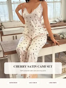 Elegante set pigiama in raso bianco con stampa ciliegie, top con pizzo e pantaloni lunghi.