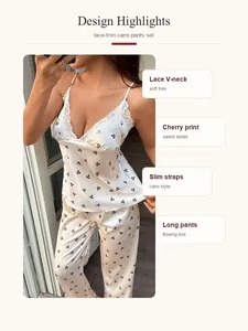 Dettaglio del pigiama bianco con stampa ciliegie, scollo a V in pizzo e spalline sottili.