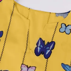 Gros plan sur le col en V et les imprimés papillons sur une robe jaune vintage tissu