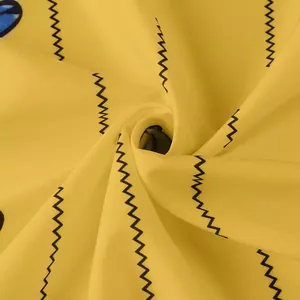 Détail macro du tissu jaune d'une robe vintage avec imprimé papillon et zigzag élégant.