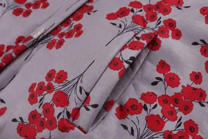 Close-up of grey floral jacket showing pocket detail and red flower pattern on thick fabric.