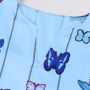 Gros plan de l'encolure en V et du motif papillon bleu sur une robe rétro bleu clair