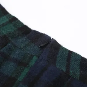 Detalle macro de una cremallera oculta en una falda de tubo clásica a cuadros verde