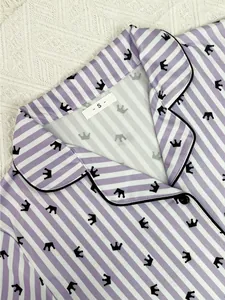 Détail du col de pyjama à rayures violettes avec imprimé de couronne et étiquette de taille