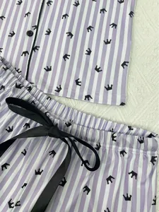 Détail de l'ensemble pyjama à rayures violettes avec imprimé couronne et nœud