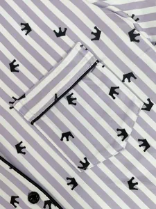Gros plan d'un haut de pyjama à rayures violettes avec imprimé couronne noire