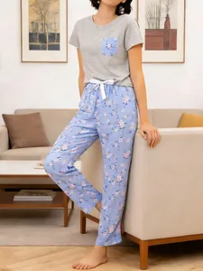 Elegant women's summer pajama set featuring grey short sleeve top and blue floral pants
