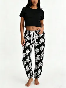 Full detail view of women's sleepwear set with black crop top and floral pants