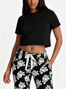 Detailed view of women's two-piece summer pajama set with floral print pants and crop top.