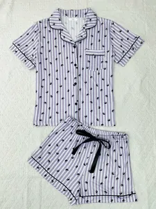 Detailed view of women's purple striped pajama set with crown print and black piping