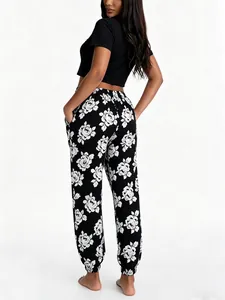Back view of women's floral pajamas set with black crop top and rose print pants