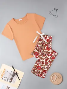 Detailed flat lay of women's orange short-sleeved pajama set featuring floral print pants.