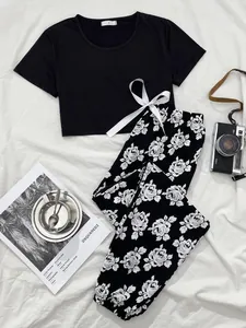 Detail of women's pajamas set with black crop top and floral print trousers