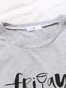 Close-up of grey pajama top neckline showing size S label and Friday print detail.