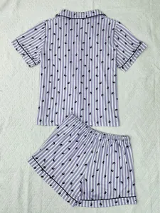 Vue détaillée à plat d'un ensemble pyjama rayé violet pour femme avec motifs de couronnes noires.