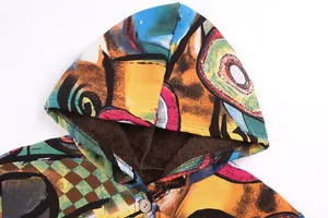 Detailed view of hood and button on a colorful artistic print fleece-lined jacket