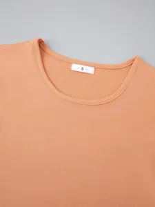 Detailed macro view of the round neckline and 'S' size label of the peach pajama top