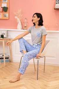 Lifestyle view of women's two-piece floral pajama set with grey top and blue pants