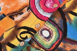 Macro view of colorful abstract print jacket featuring natural wooden button details on fabric