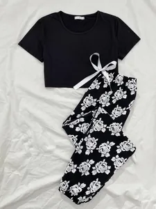 Two-piece pajama set featuring a black short sleeve crop top and floral print long pants