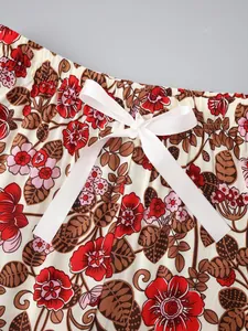 Close-up of floral print pajama pants with elastic waist and white ribbon bow detail.