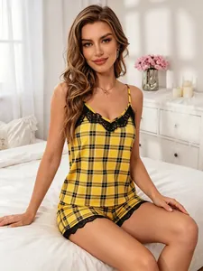 Dettaglio di un set pigiama a quadri gialli con pizzo nero indossato da una modella