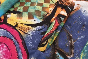Close-up macro view of vibrant abstract graffiti print on thickened fleece jacket fabric