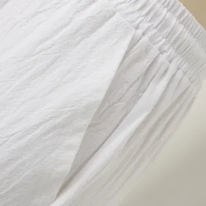 Detaillierte Makroansicht einer weißen Leinenhose mit elastischem Bund und Seitentasche