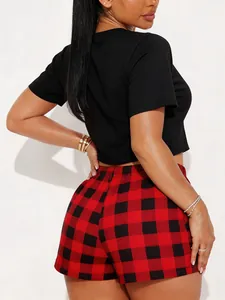 Detailed back view of women's red buffalo plaid pajama shorts paired with a black crop top
