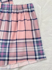 Dettaglio di pantaloncini del pigiama a quadri rosa con elastico in vita e tessuto.