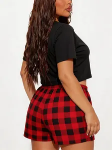 Detailed back view of women's black short sleeve crop top and red plaid pajama shorts