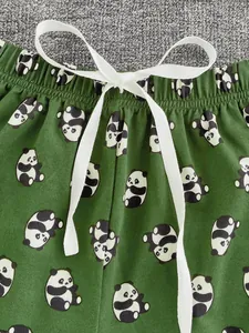 Dettaglio dei pantaloni del pigiama verde scuro con stampa panda e coulisse bianca