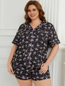 Plus size two-piece pajama set featuring a delicate pink bow pattern on soft black fabric