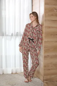 Full-body detail of a woman wearing a red leopard print pajama set in a cozy room